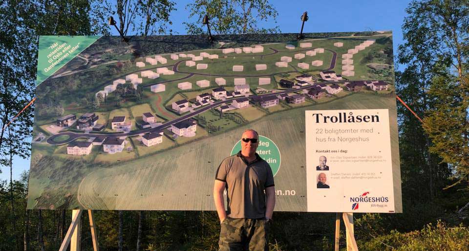 Utendørs skilt for byggeprosjekt i Trollåsen, med daglig leder Olav i front